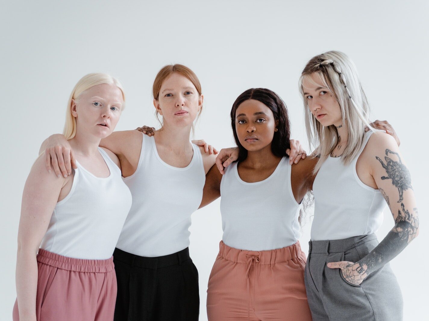Women in White Tank Top Standing Side by Side