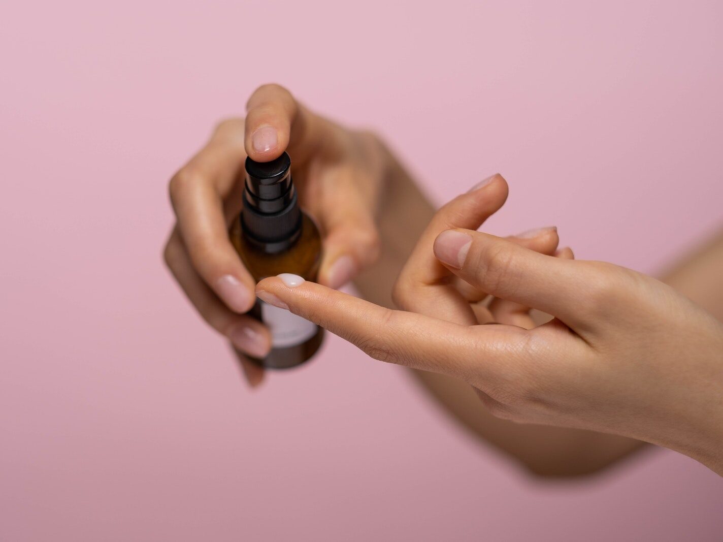 Person Holding Brown Spray Bottle