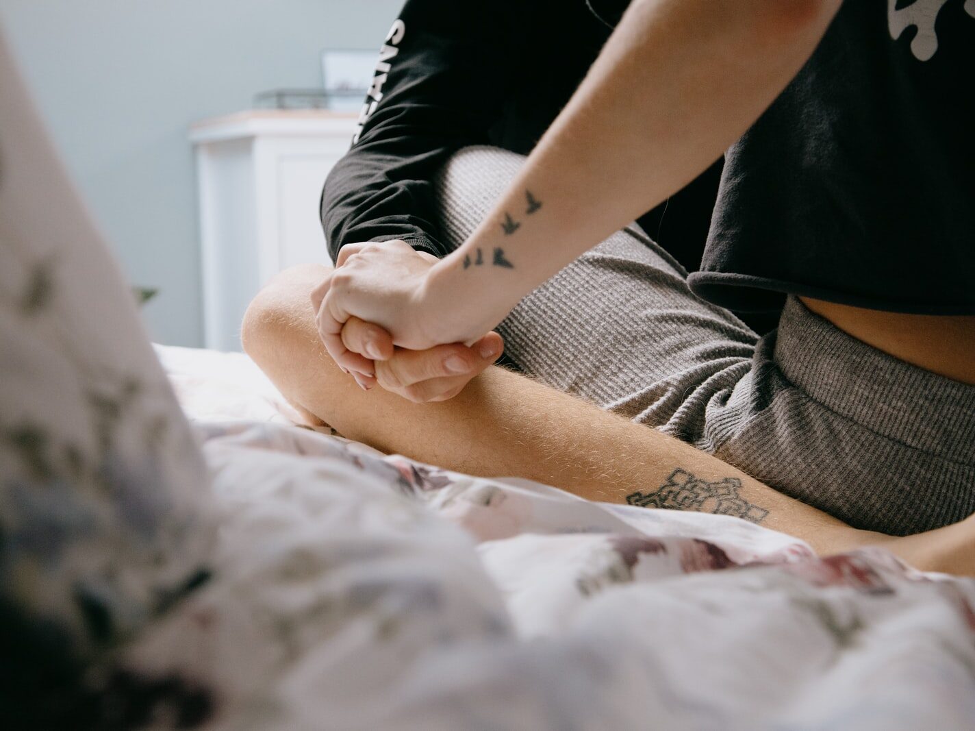 woman in black shirt and black pants sitting on bed