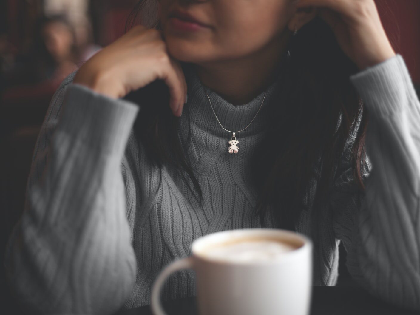 cup of coffee in front of woman