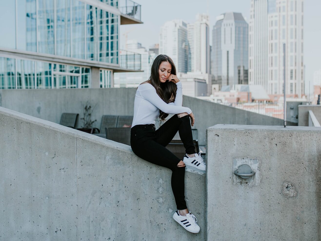 woman sitting on concrete building