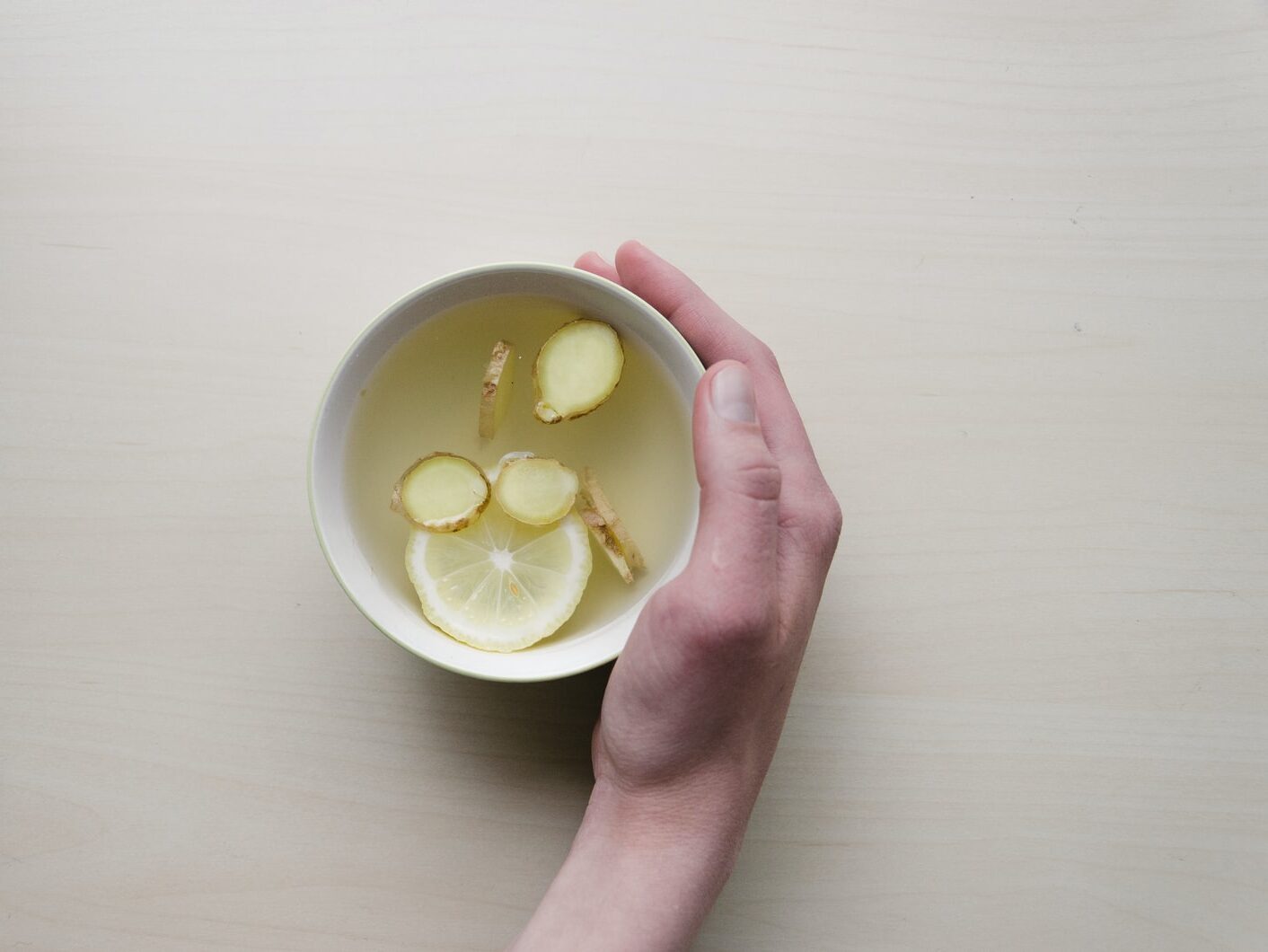 - ČasProŽeny.cz person holding white bowl with sliced lime and ginger inside