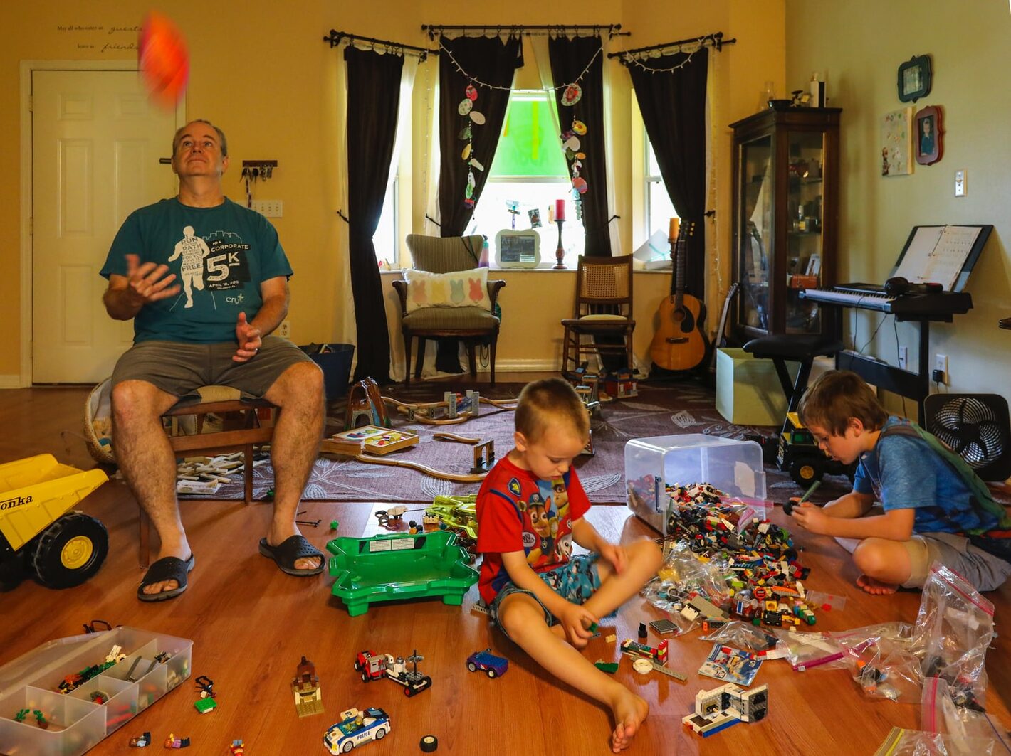 man in gray crew neck t-shirt sitting beside boy in red and white crew neck