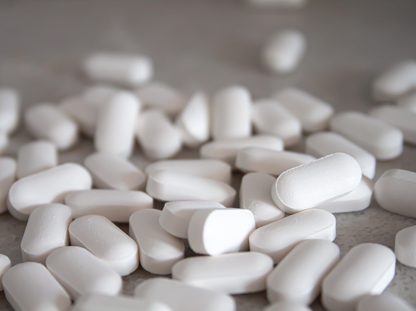 white medication pills on brown surface