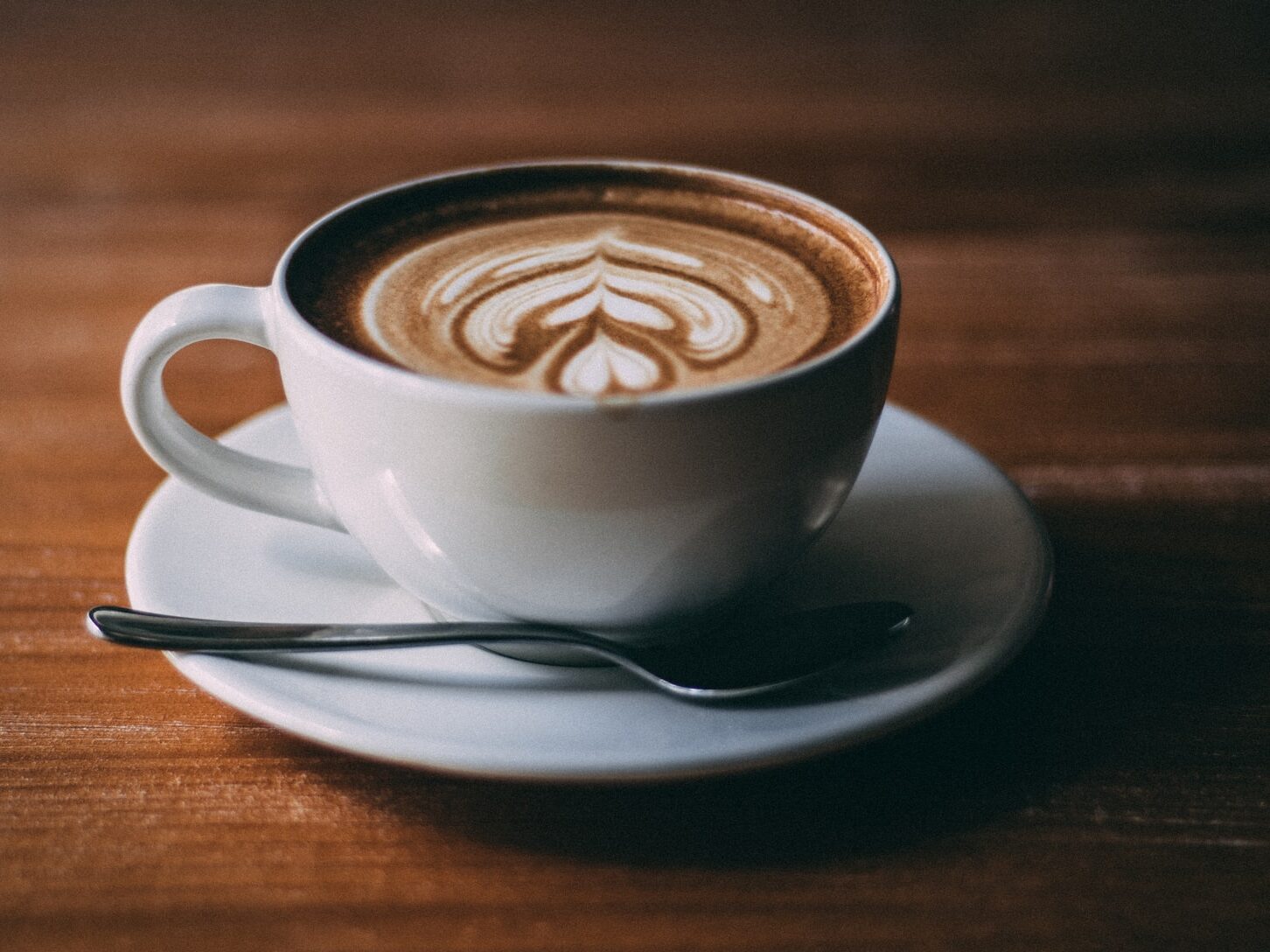 white ceramic teacup with coffee latte art