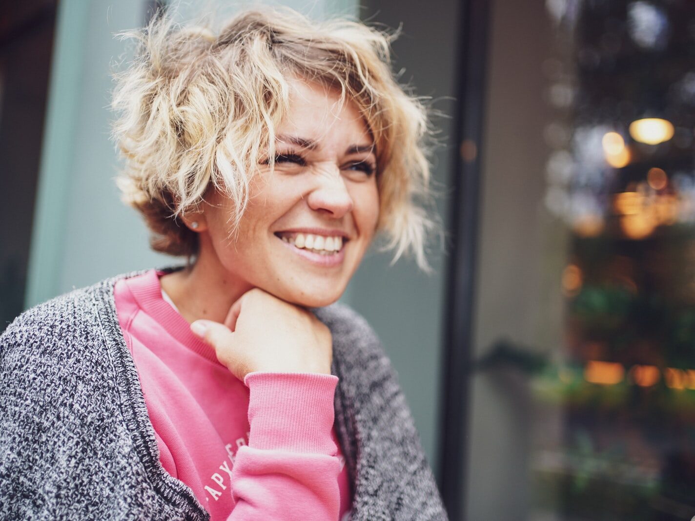 smiling girl in pink shirt and gray cardigan