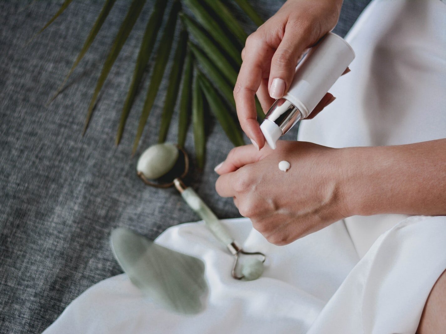 person holding white plastic bottle pouring white liquid on white ceramic mug
