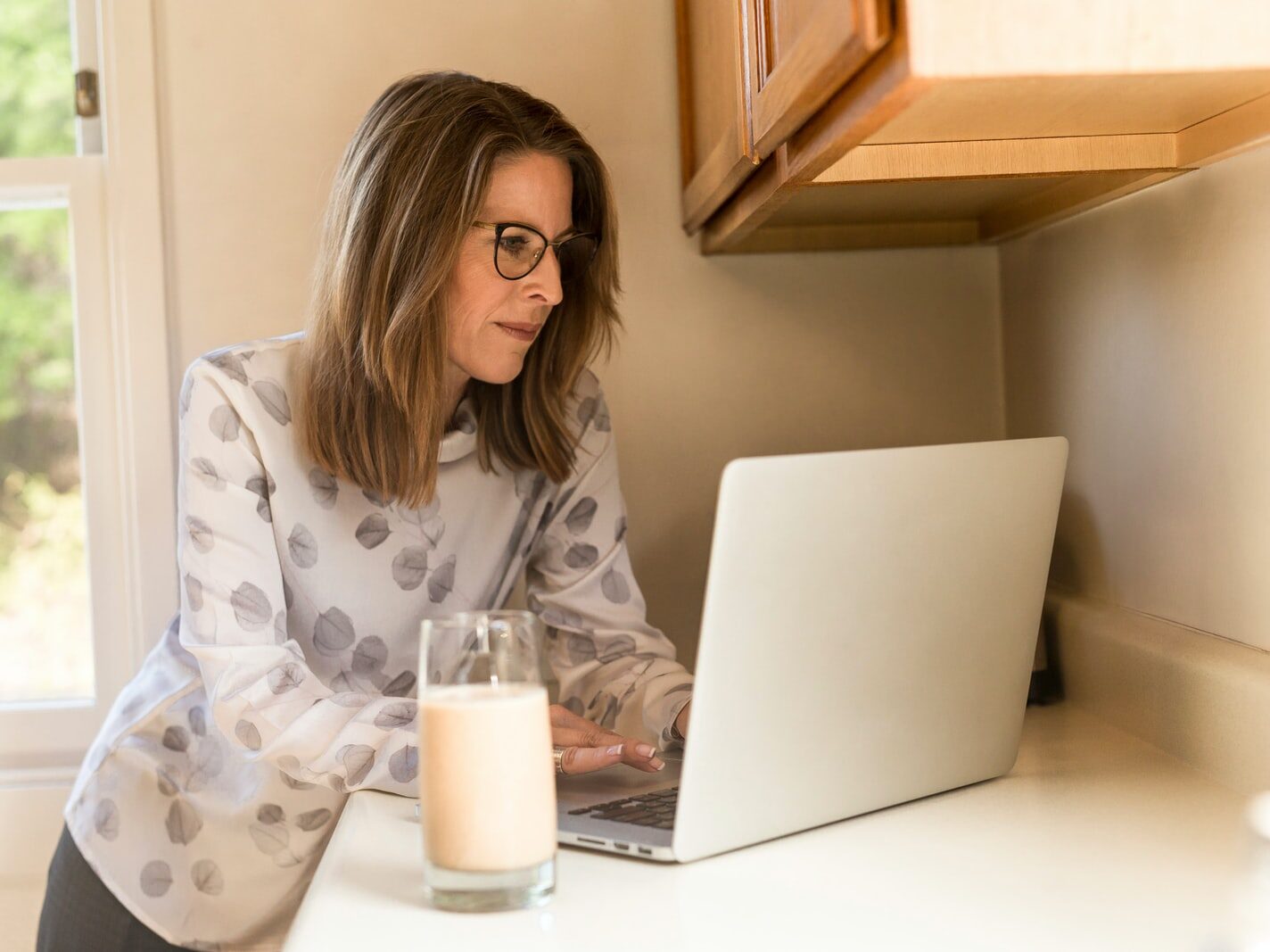 woman using her MacBook Pro inside white room