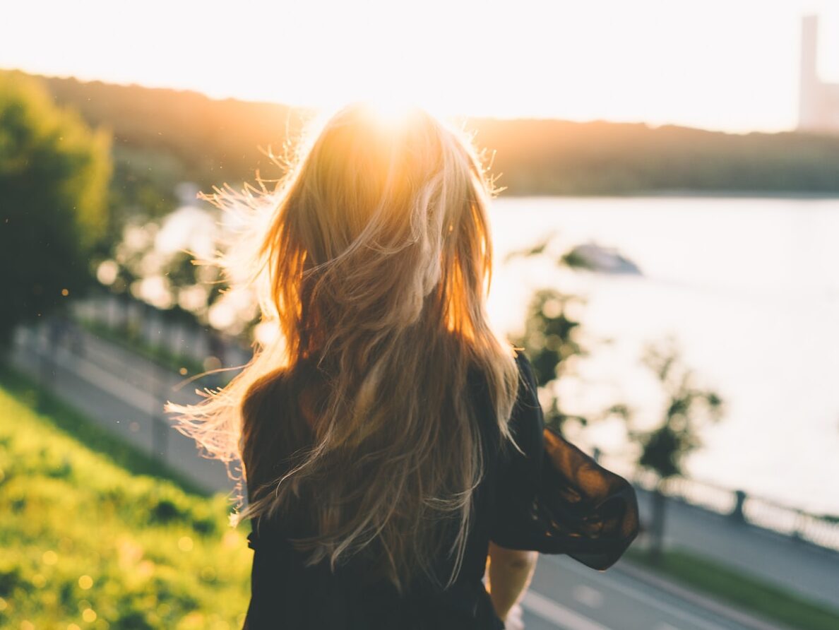 woman sitting while looking at the sunset
