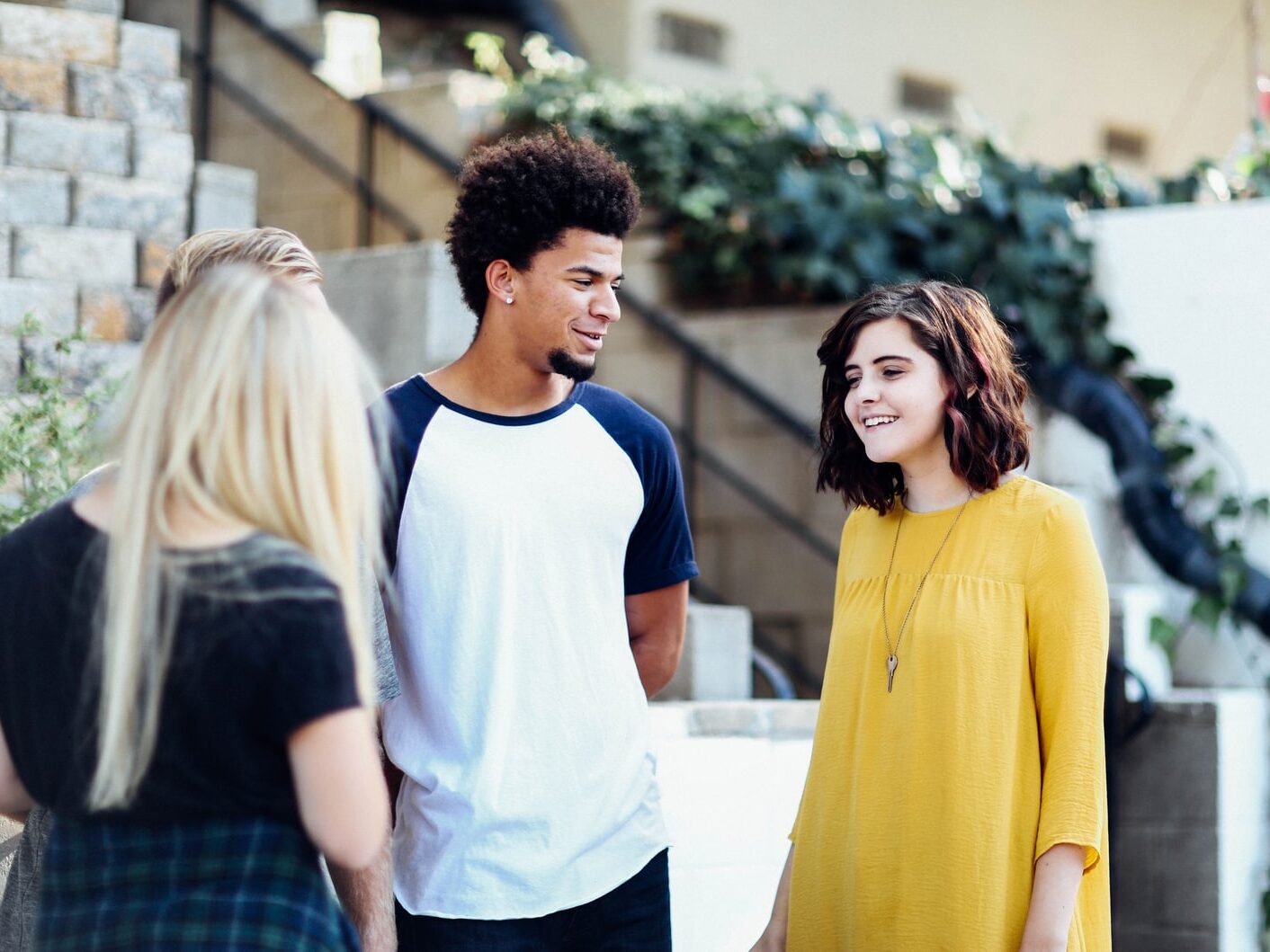 women and man talking outside the building