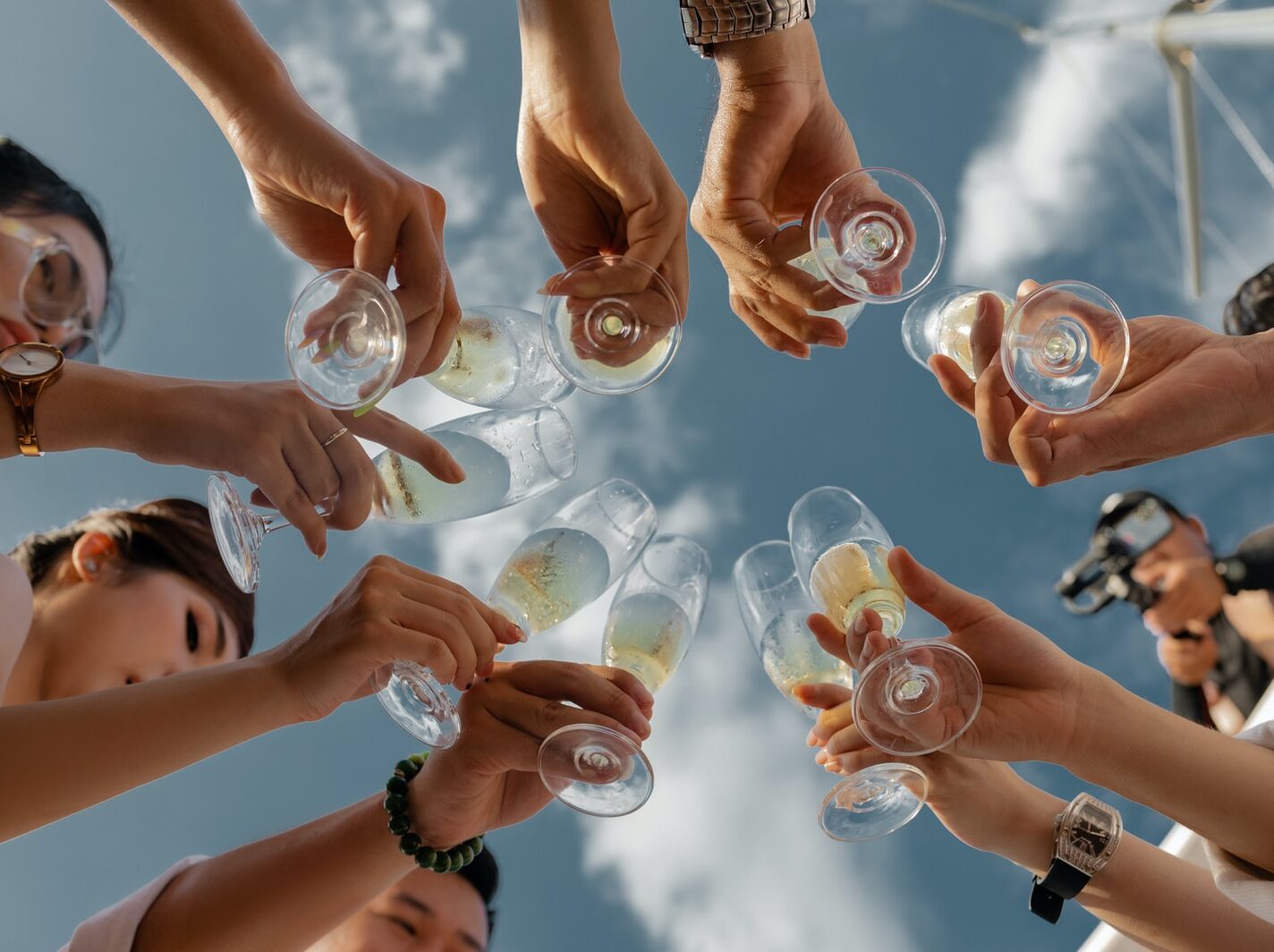 people holding clear glass bottles during daytime