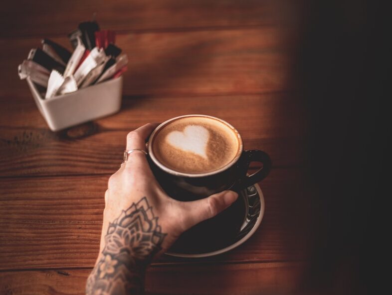person holding black ceramic mug with coffee