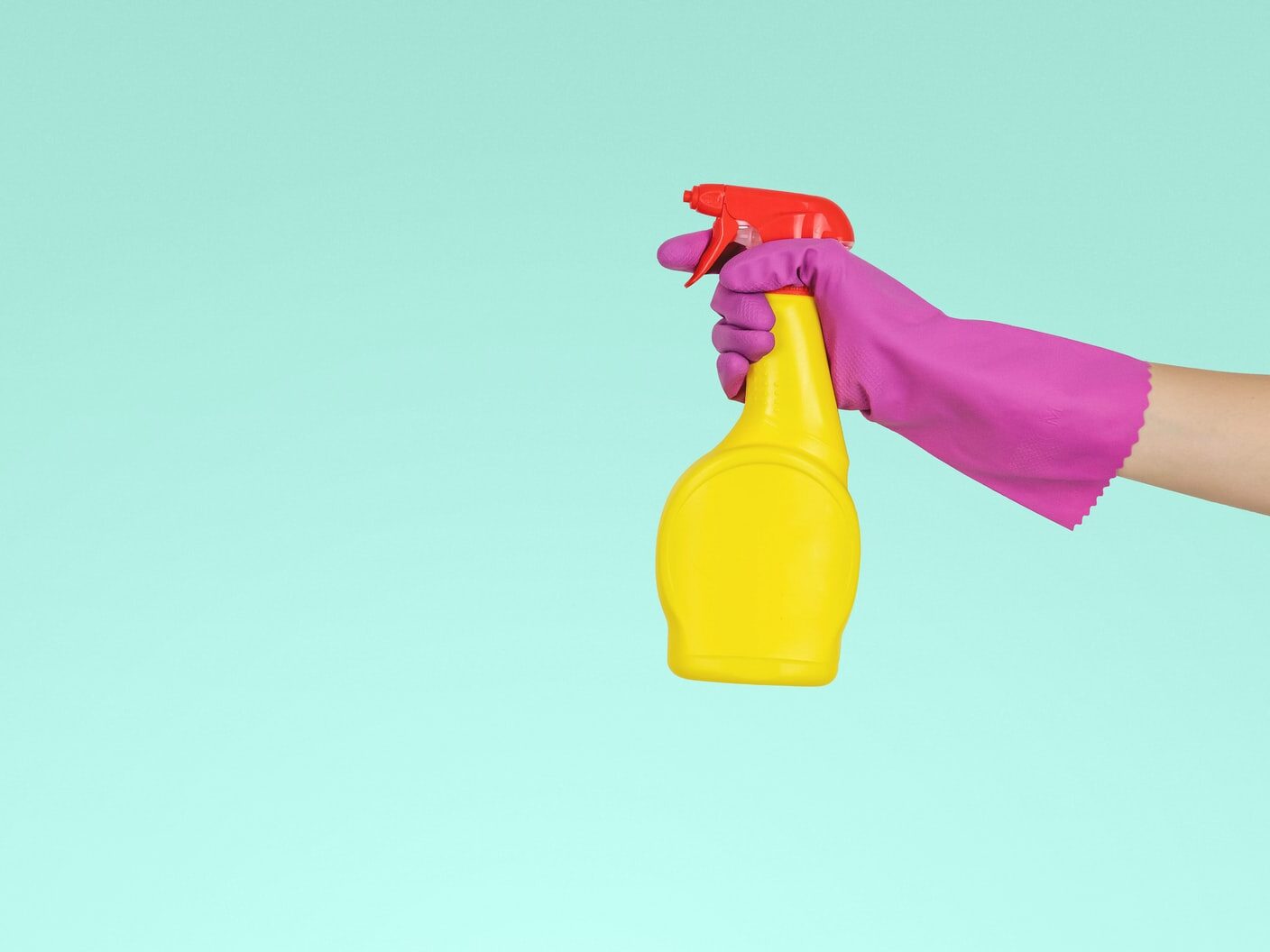 person holding yellow plastic spray bottle