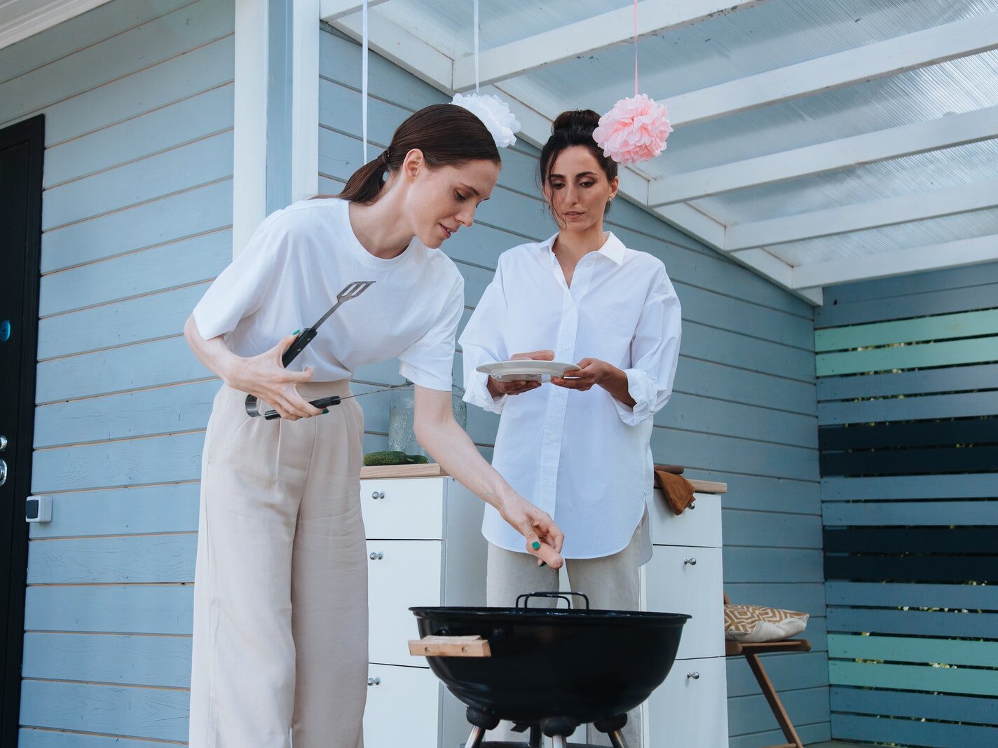 A Woman Putting Hotdog on the Griller