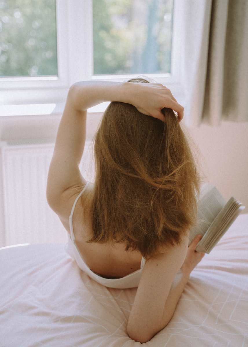 Nadi Lindsay - ČasProŽeny.cz Back View of a Woman Sitting on a Bed while Holding a Book