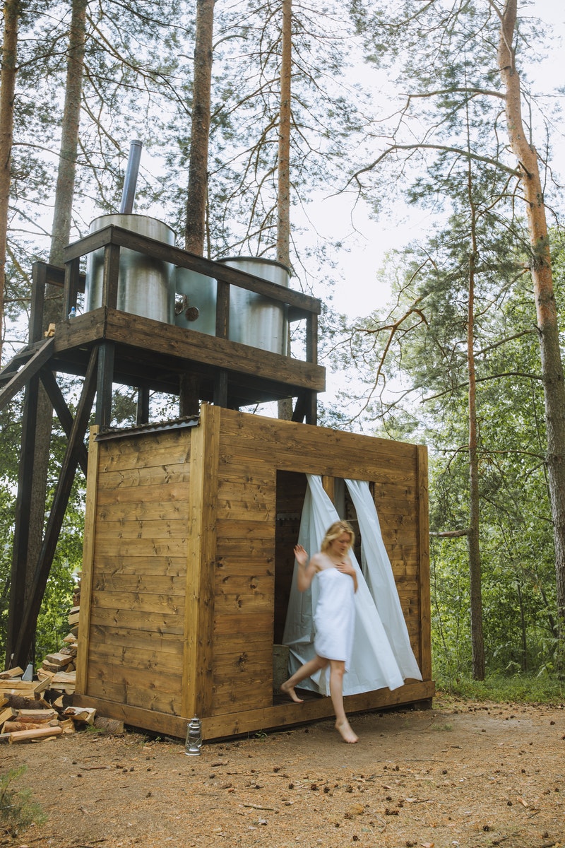 Woman Wrapped in White Towel Coming Out From a Wooden Bathroom