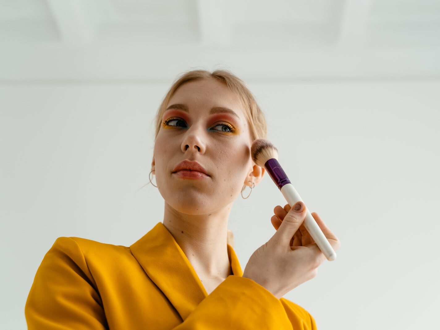 Woman in Yellow Blazer Putting Blusher on Her Face