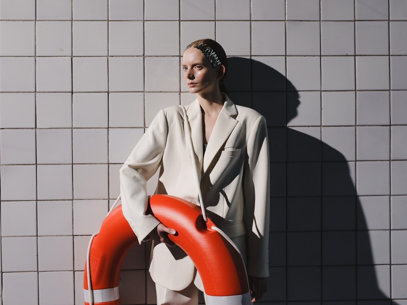 Man in White Blazer Standing Beside Red and White Inflatable Ring