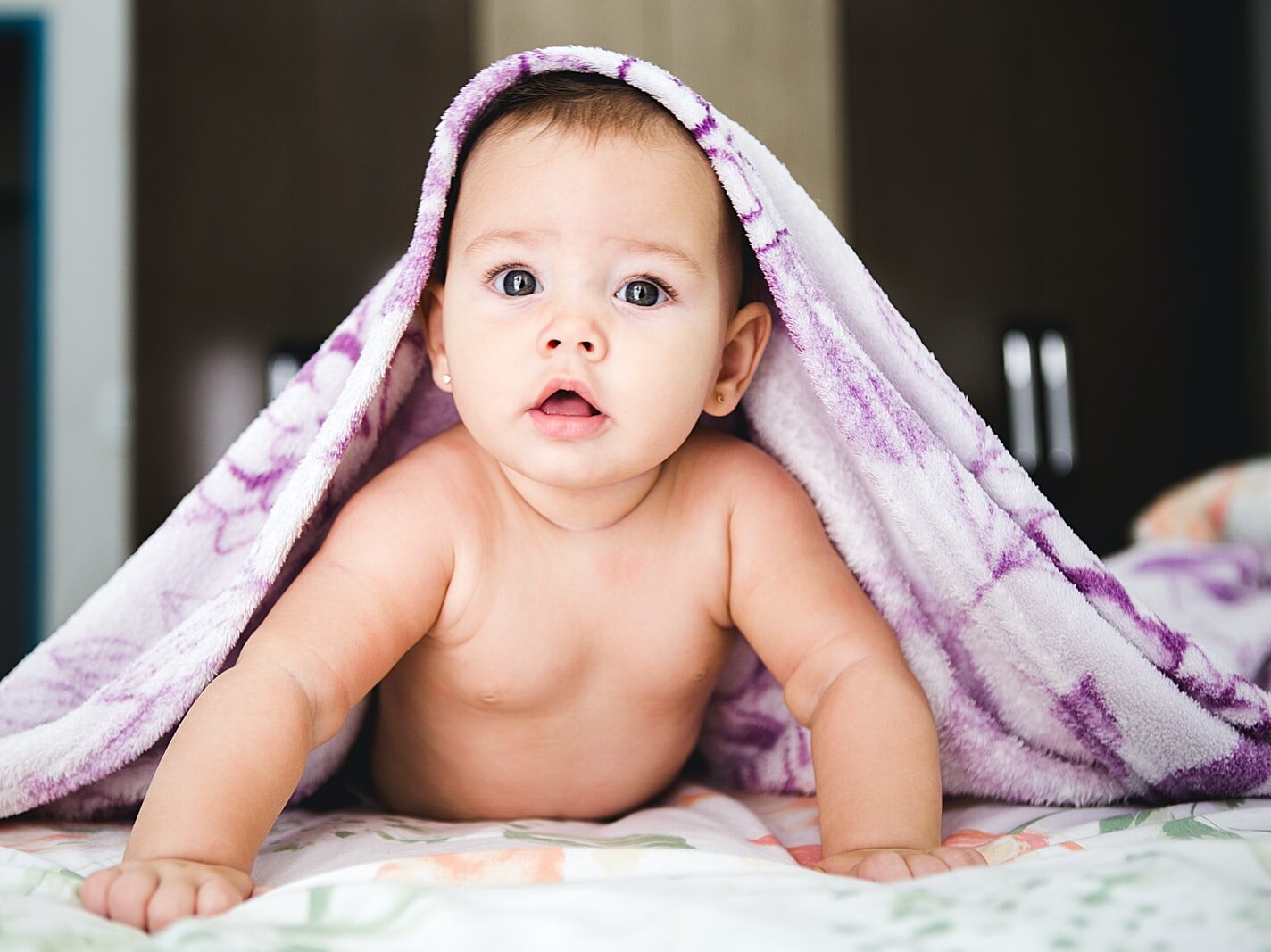 baby under purple blanket
