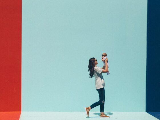 woman carrying baby while walking