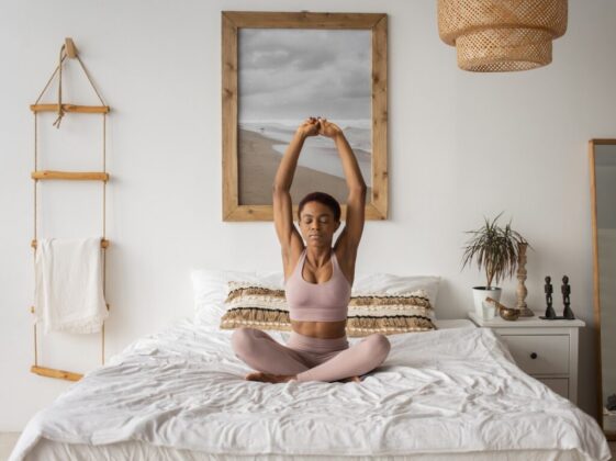 Photo of a Woman Doing a Yoga Pose on Her Bed