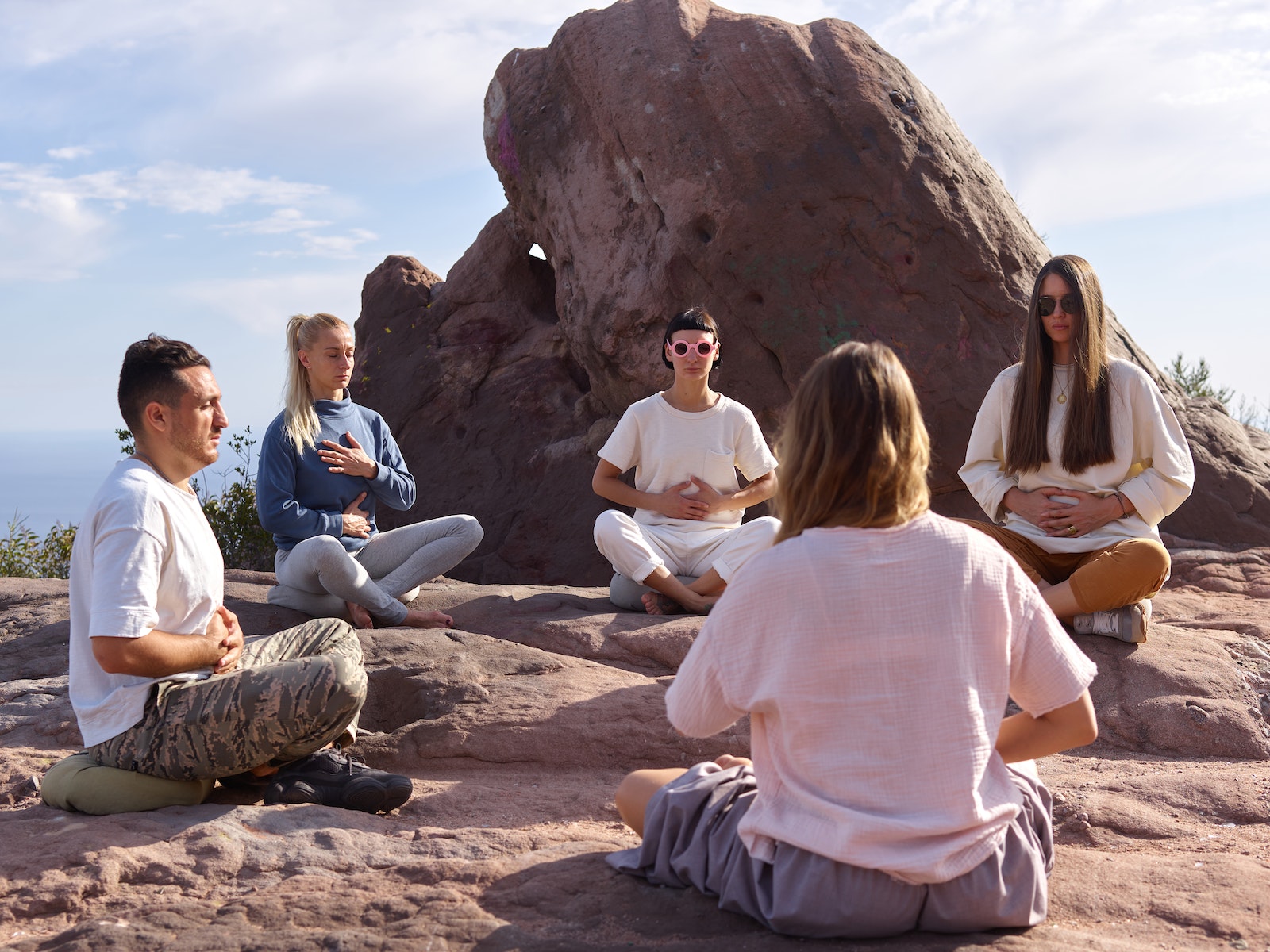 3 Women Sitting on Brown Rock