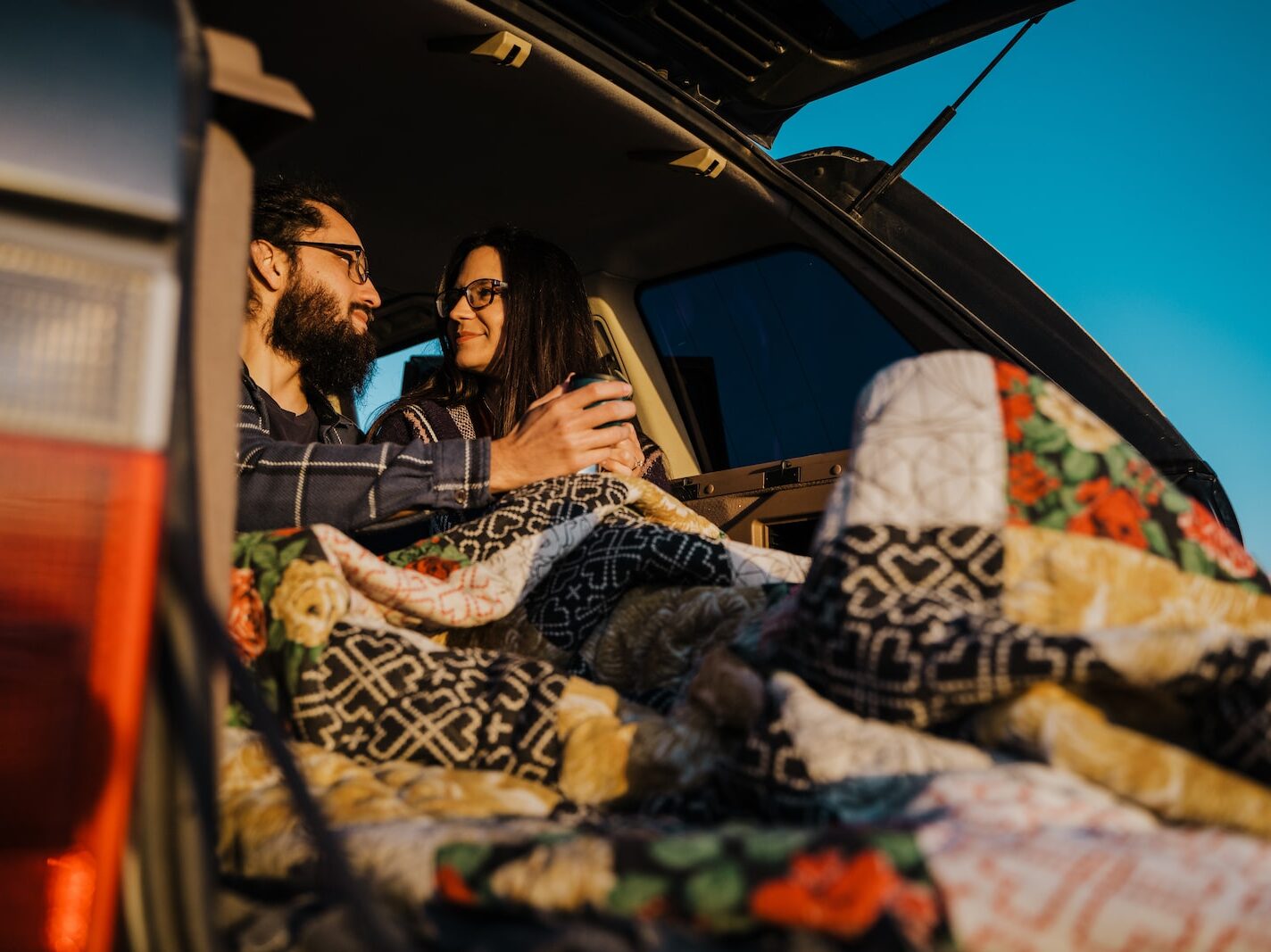 man and woman sitting on car during daytime