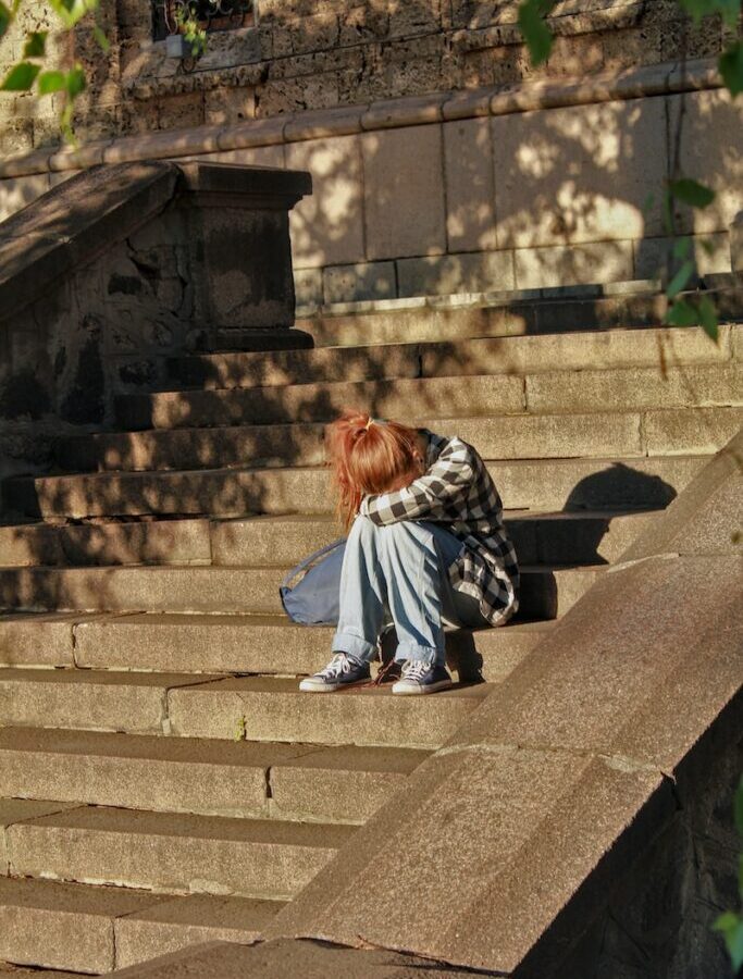 woman in black and white dress sitting on concrete stairs