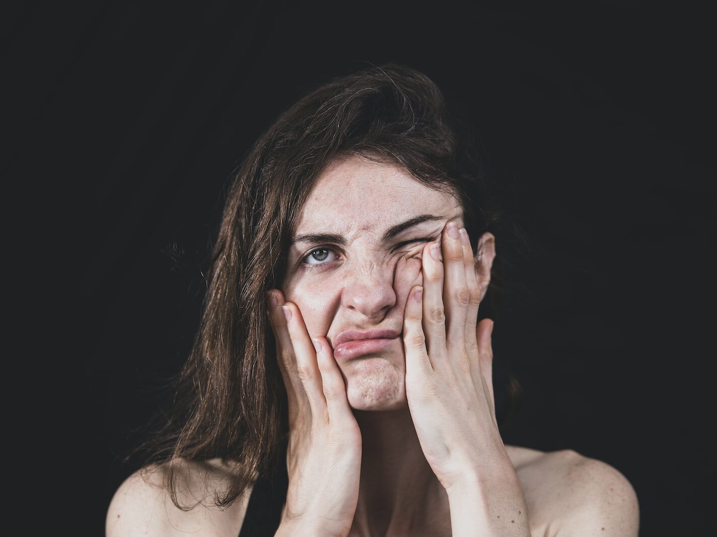 woman covering her face with her hand