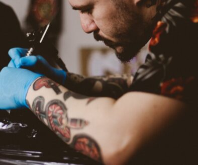 man doing tattoo on person's arm