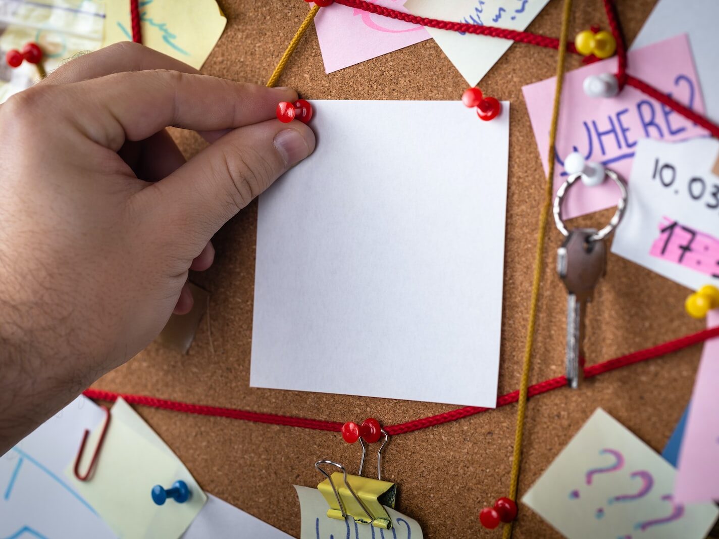 shallow focus photo of white paper sheet mounted on cork board