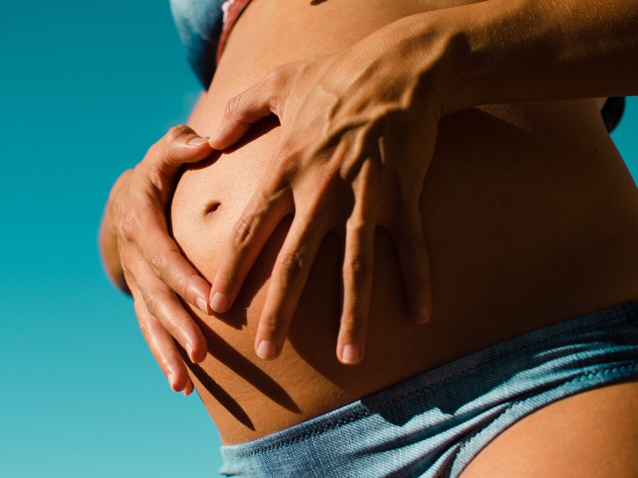 closeup photography of pregnant woman wearing blue panty