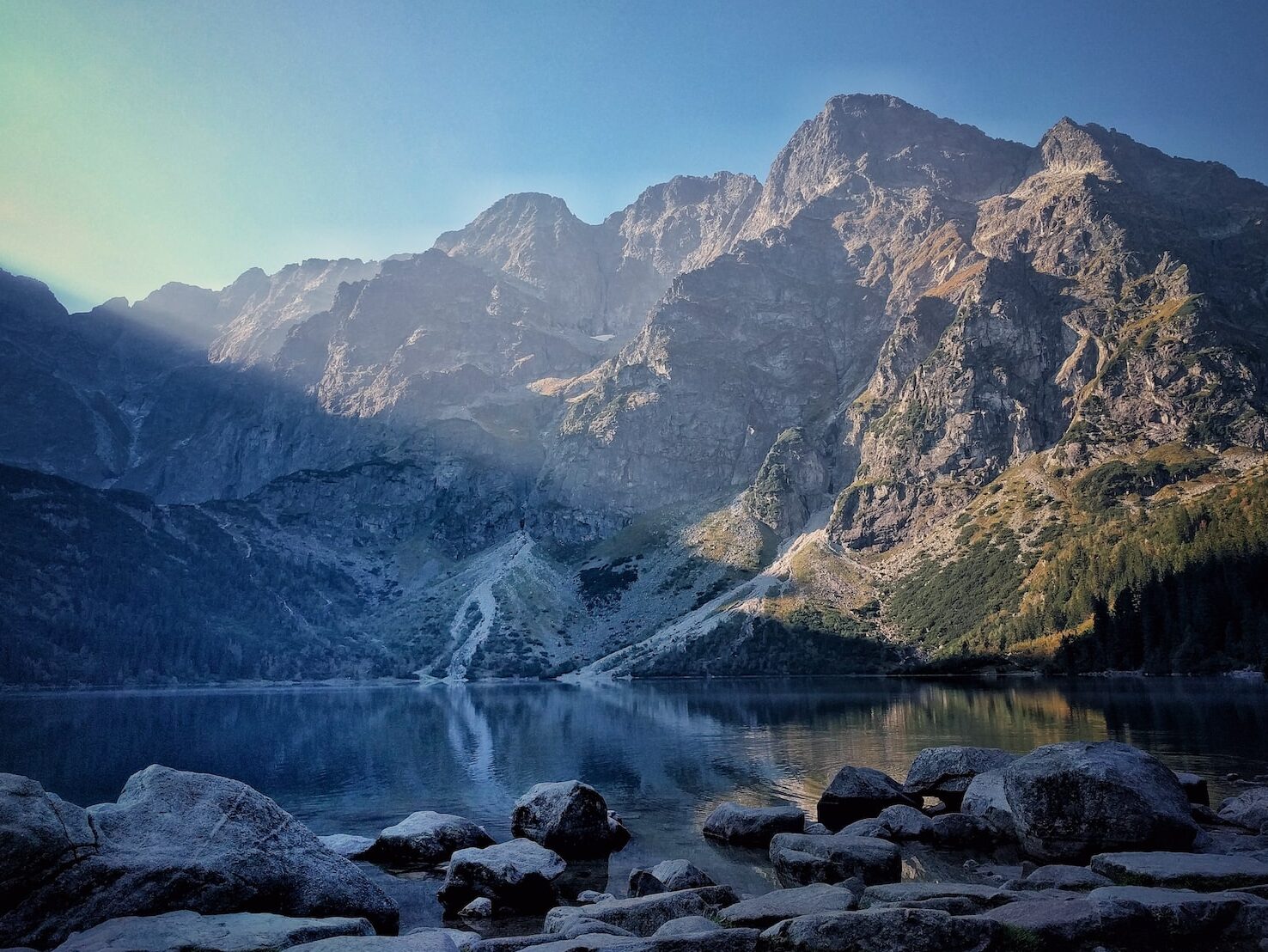 calm water front of mountain at daytime