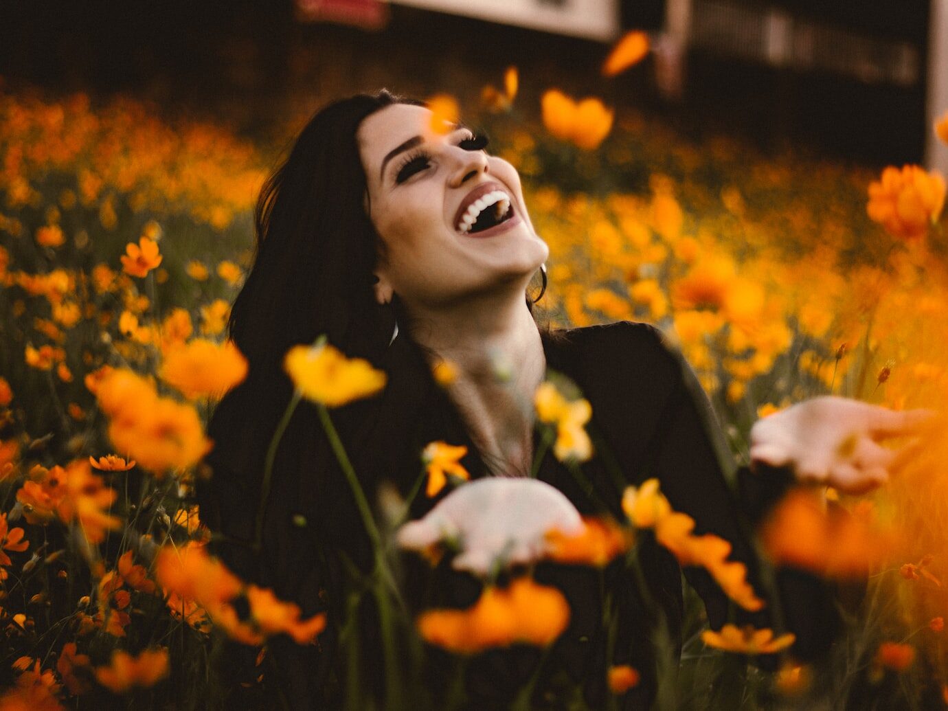 woman laughing on flower field