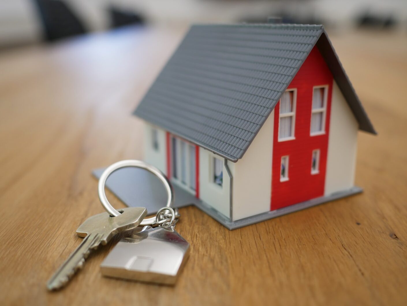 white and red wooden house miniature on brown table