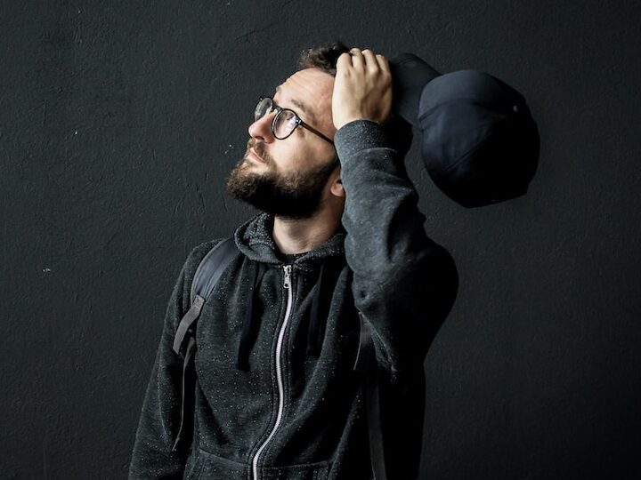 man looking up holding his hair