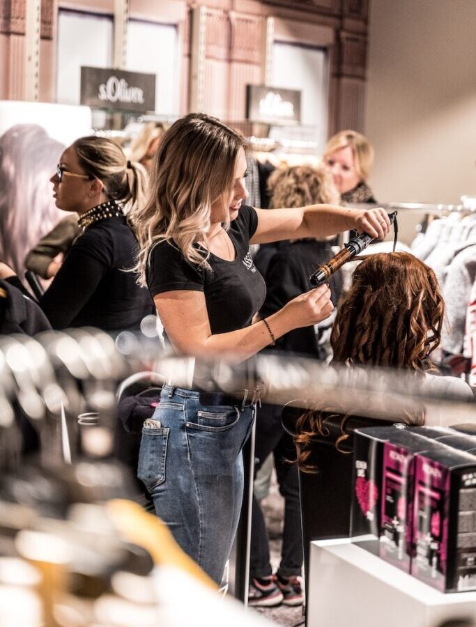 Woman Curling Another Woman's Hair