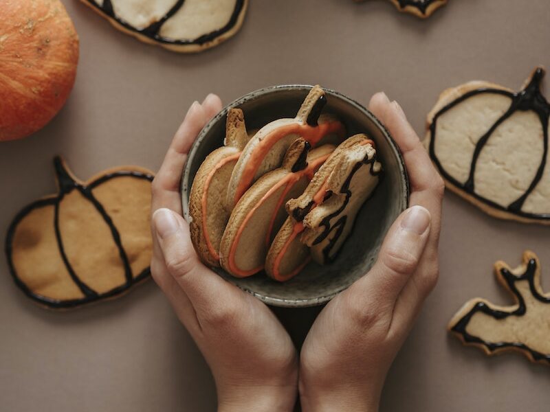 A Person Holding a Bowl of Halloween Cookies