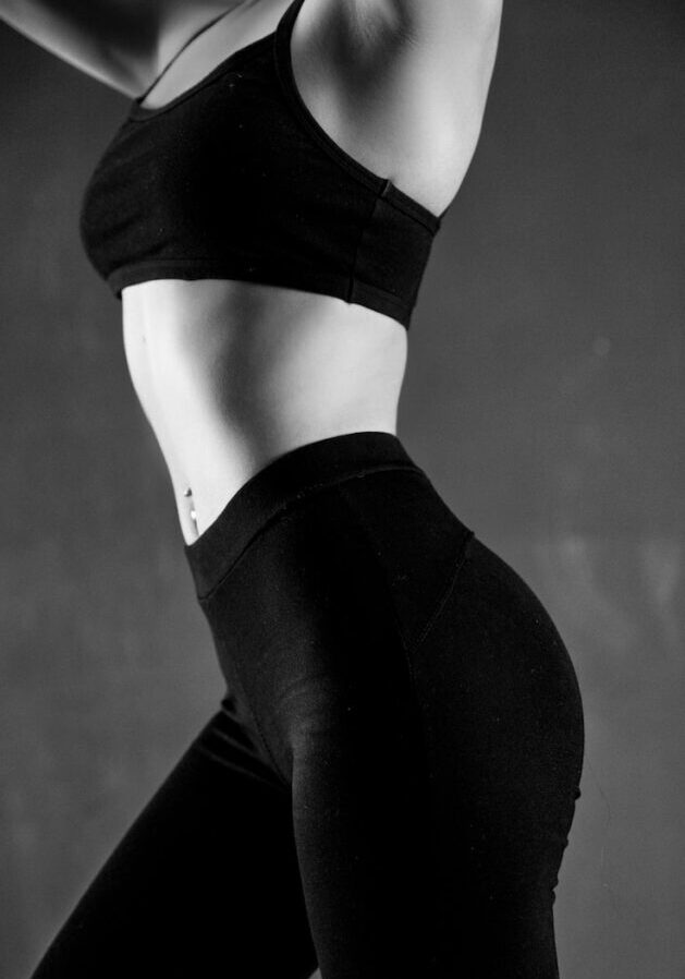 grayscale photo of person wearing sports bra and leggings