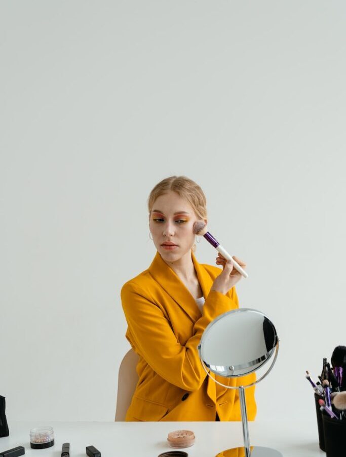 Woman in Yellow Blazer Applying Makeup