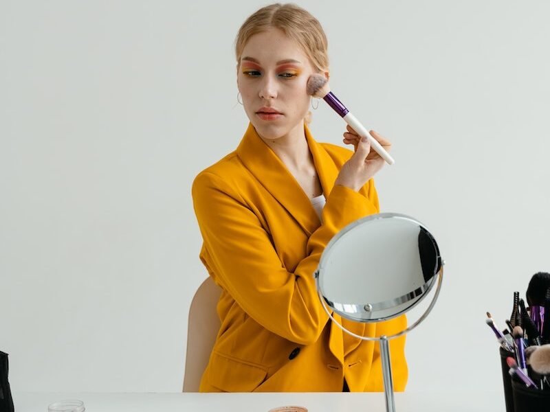 Woman in Yellow Blazer Applying Makeup