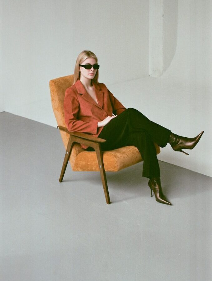Woman in Green Blazer Sitting on Brown Wooden Chair