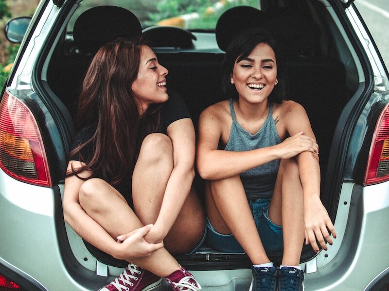 two women sitting at the back of the car