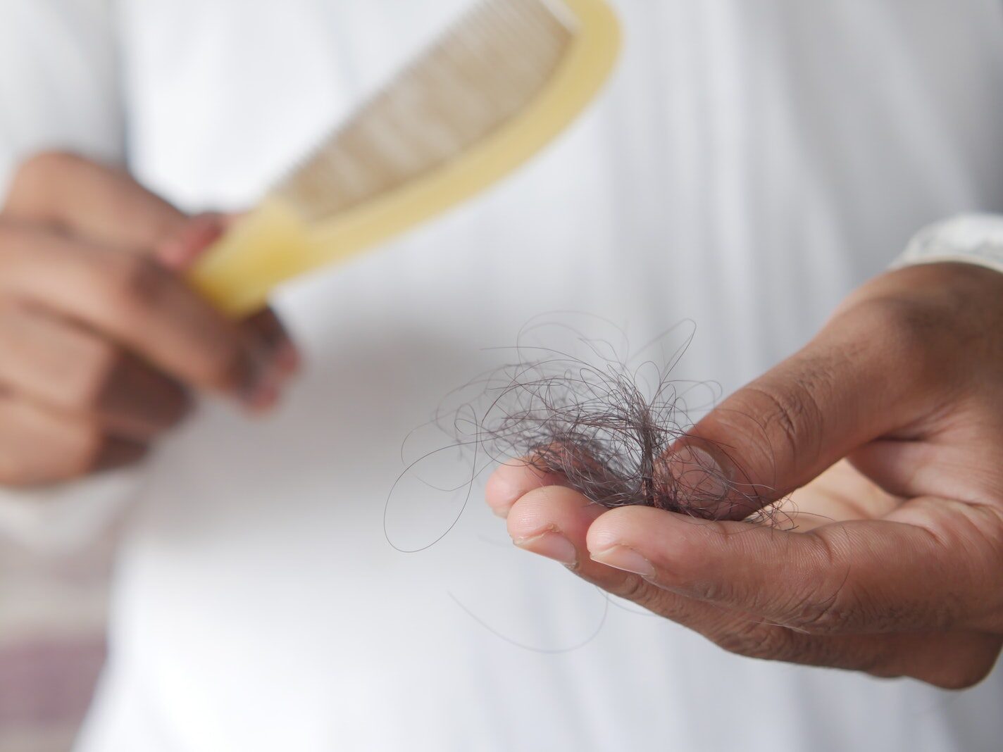 Close Up Photo of a Person Holding Hair