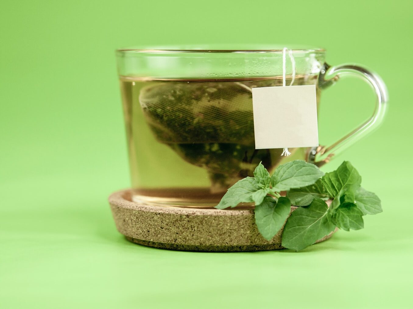 clear glass mug with green leaves