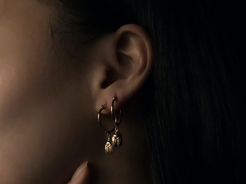 woman wearing silver heart stud earring