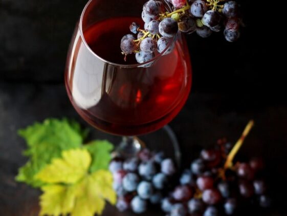 red grapes on clear glass wine