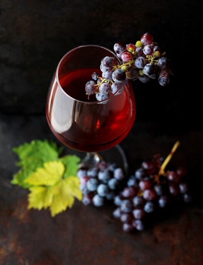 red grapes on clear glass wine