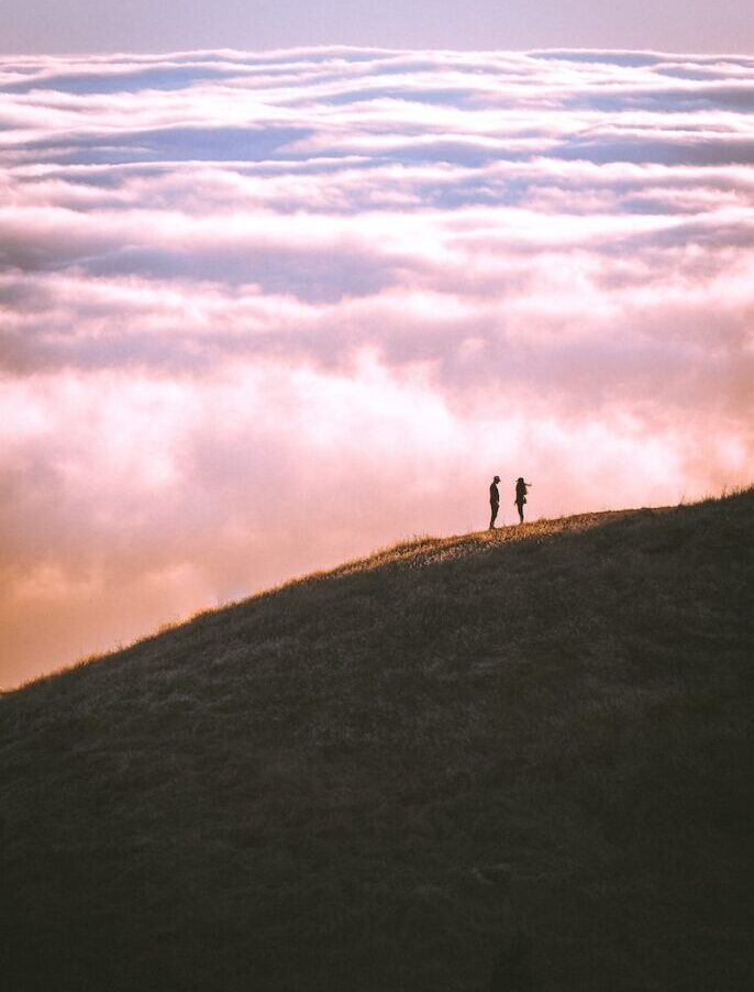 couple standing on grass field mountain