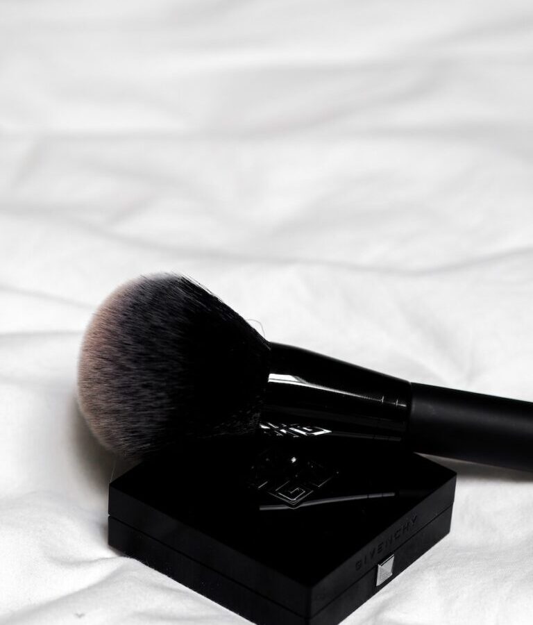 black make up brush on white textile